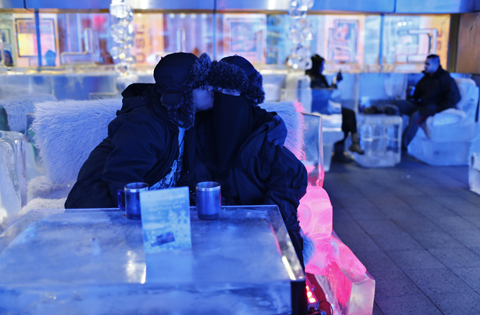 Honeymooner Ahmed, form Saudi Arabia who got married last week, kisses his veiled bride at Chillout cafe in Dubai May 12, 2013. Chillout, owned by UAE's Sharaf Group, is the first ice lounge in the Middle East, with temperatures set at -6 degrees Celsius (21 degrees Farenheit). The cafe, with its illuminated interiors, curtains, paintings and seating arrangements, is all made of carved ice and frozen sculptures. REUTERS/Ahmed Jadallah (UNITED ARAB EMIRATES - Tags: SOCIETY TPX IMAGES OF THE DAY)