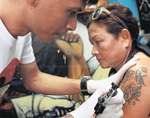 Những sai lầm khi xóa xăm 2 Bongkod cẩn thận tô điểm cho hình xăm trên cánh tay của mẹ.